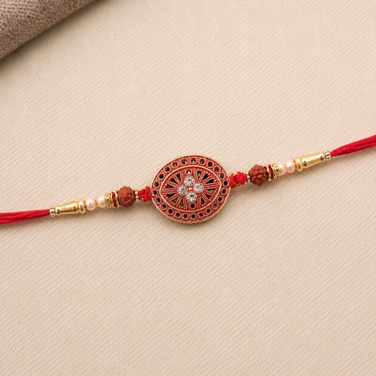 Round Red Chakra Rakhi with Golden Beads and Pearl Side Work