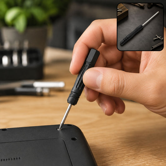 A hand uses a black and silver mini screwdriver to tighten a screw on a black device.
