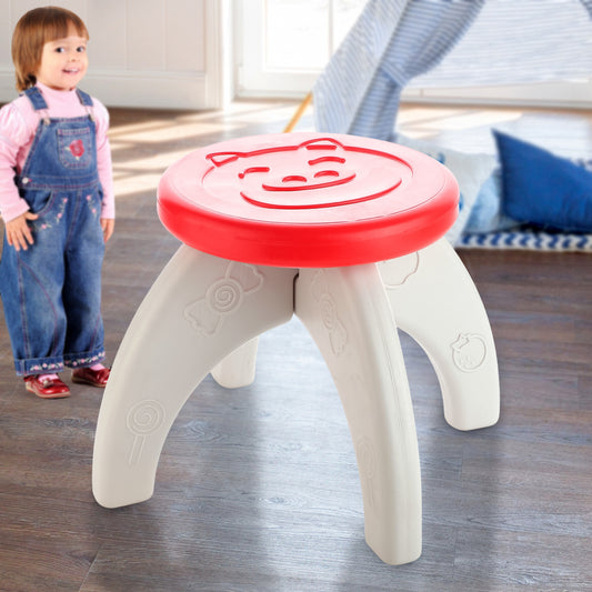 A young girl stands next to a small red and white plastic stool with a pig face on top.