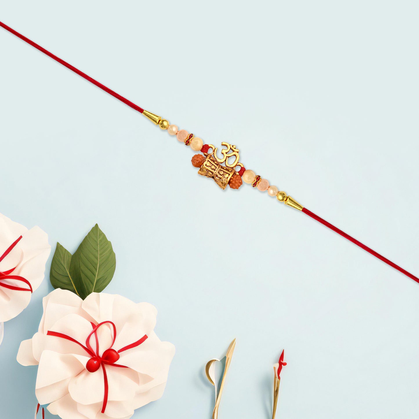 Close-up of Golden Charm Rakhi showing pearl beads