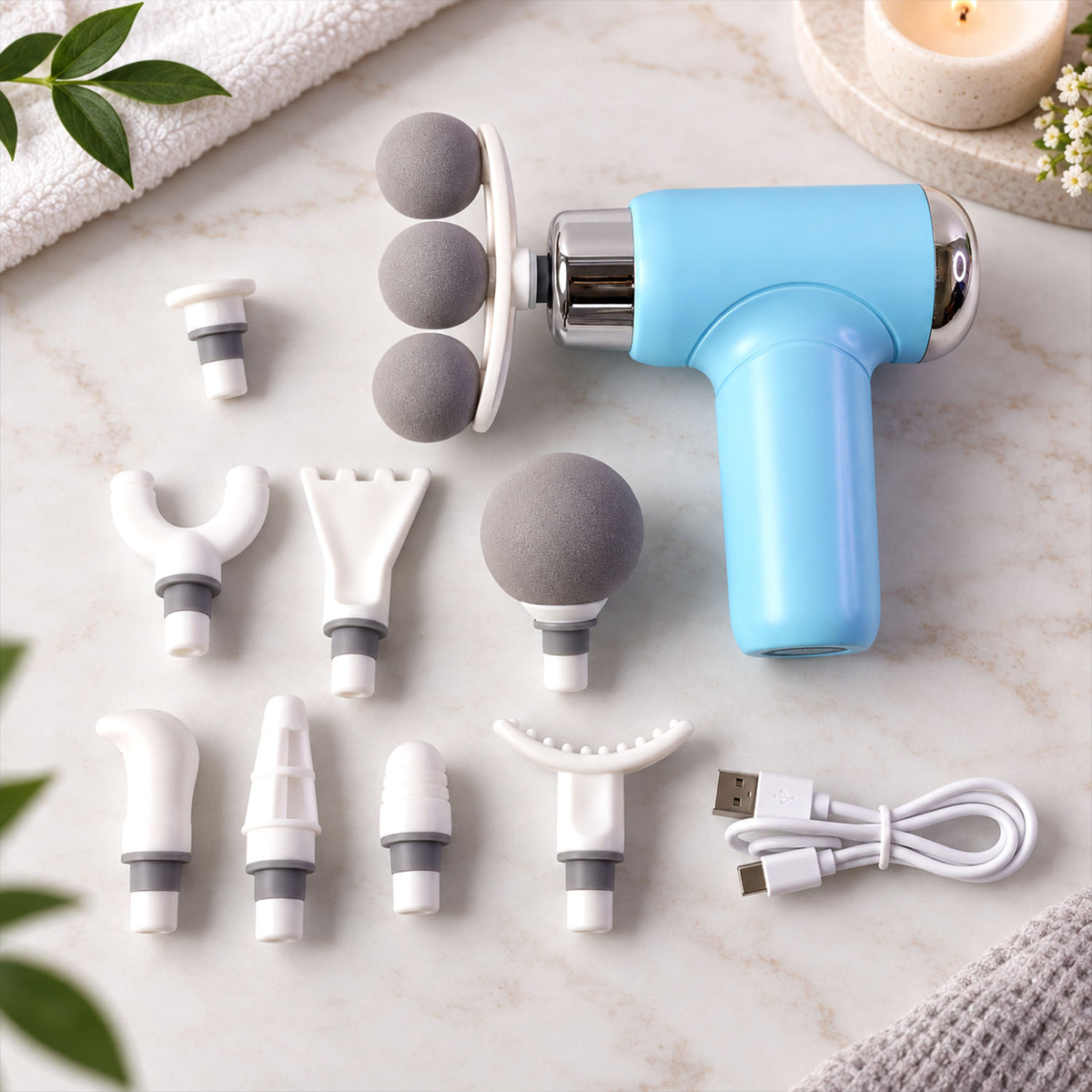 A light blue massage gun with various grey and white interchangeable heads and a white USB-C charging cable.