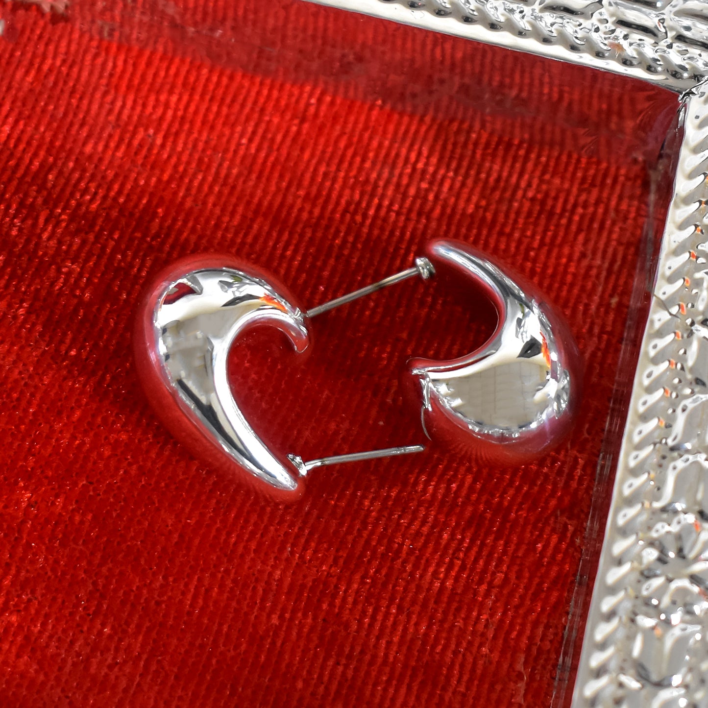 Woman wearing Kaju design earrings, showcasing their elegant drape and traditional style.
