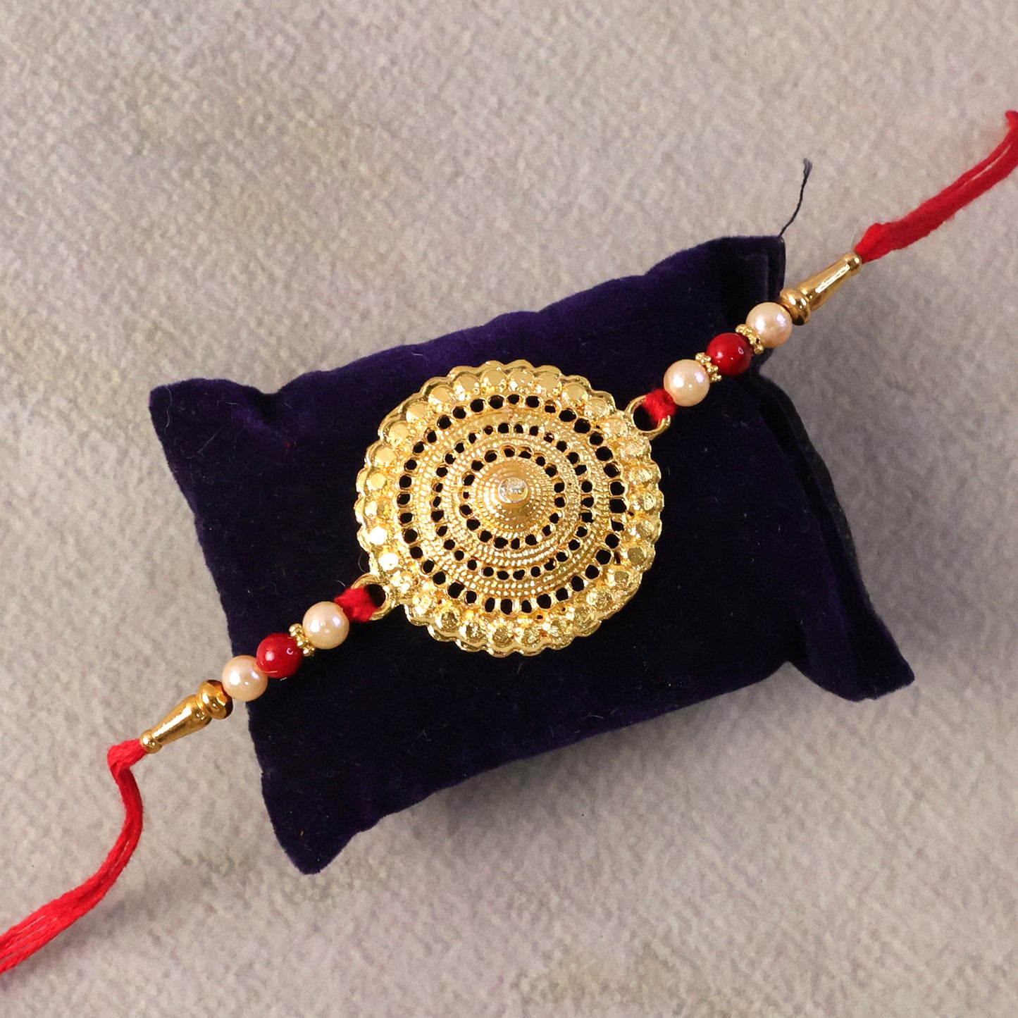 Elegant Rakhi showcasing gold centerpiece and pearl beads