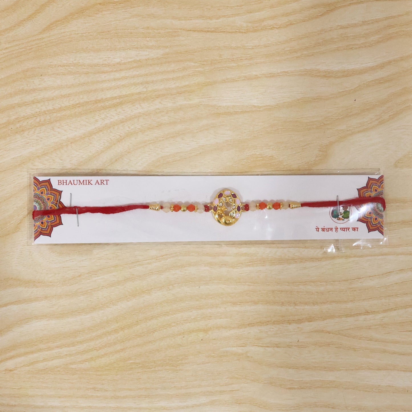 Close-up of designer rakhi with peacock centerpiece and colorful beads
