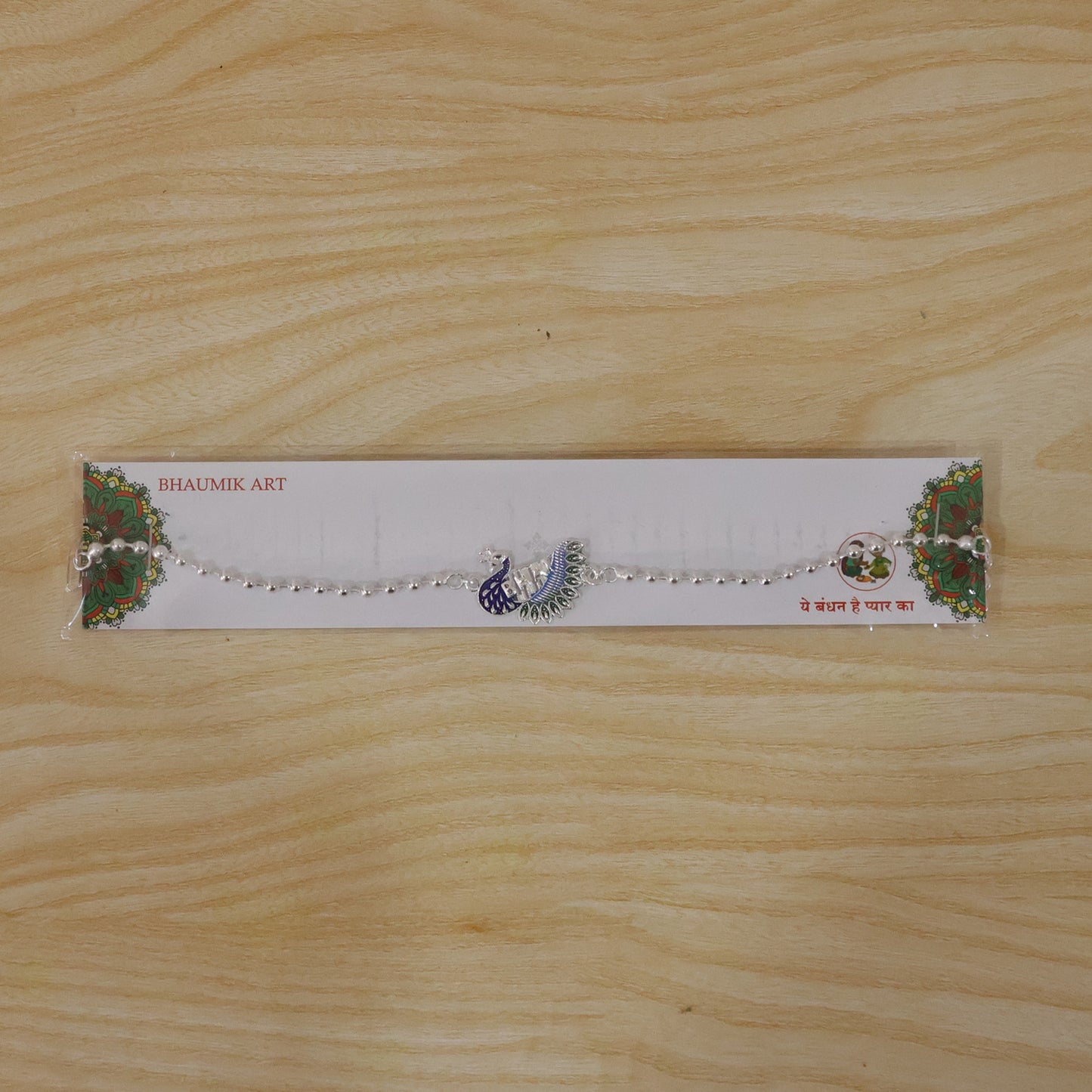 Silver peacock Rakhi styled on a festive surface