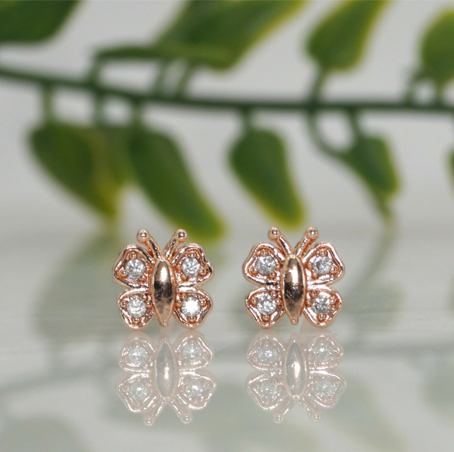 Rose gold butterfly stud earrings with sparkling AD stones front view