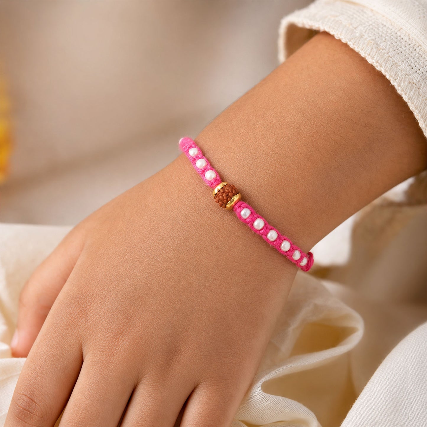 Pink-White Braided Rakhi with Natural Rudraksha Bead Pendant