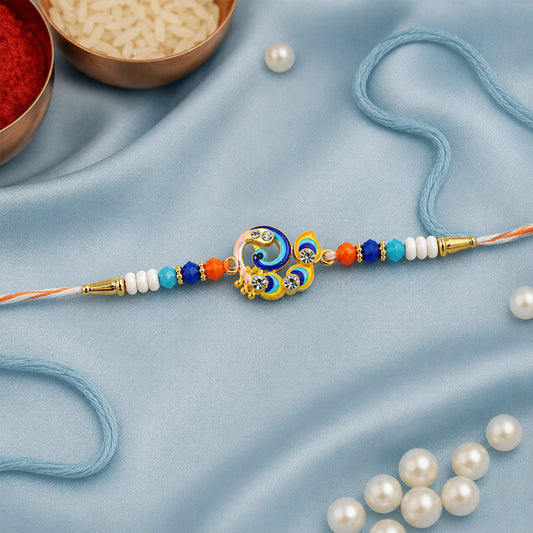 A vibrant peacock-shaped charm with blue, yellow, and white enamel, adorned with clear stones, is centered on an orange and