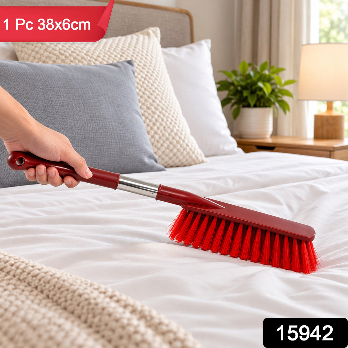 A hand holds a red and silver extendable brush, sweeping white bed linens. Product information is overlaid.