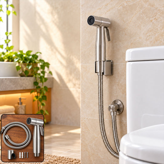 A brushed steel bidet sprayer with a flexible hose is mounted on a tiled wall next to a white toilet in a bright bathroom