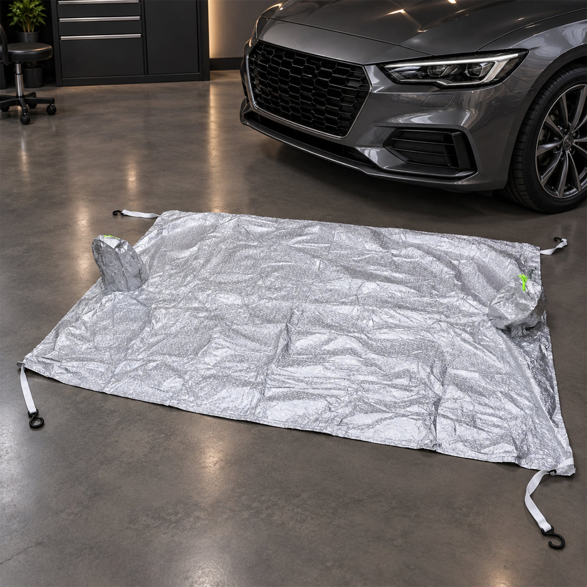 Windshield cover laid out beside a car