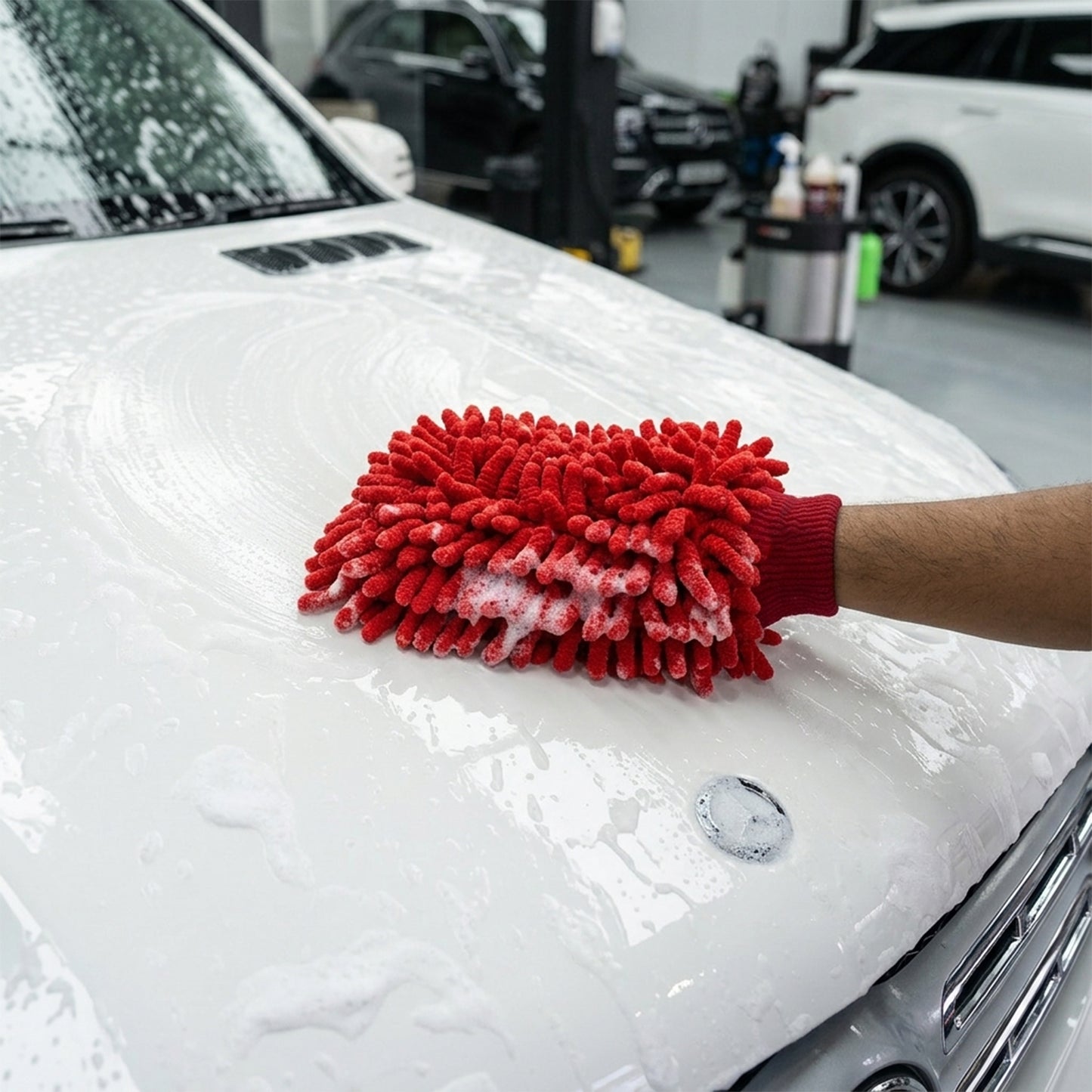 Red microfiber wash glove cleaning a car surface