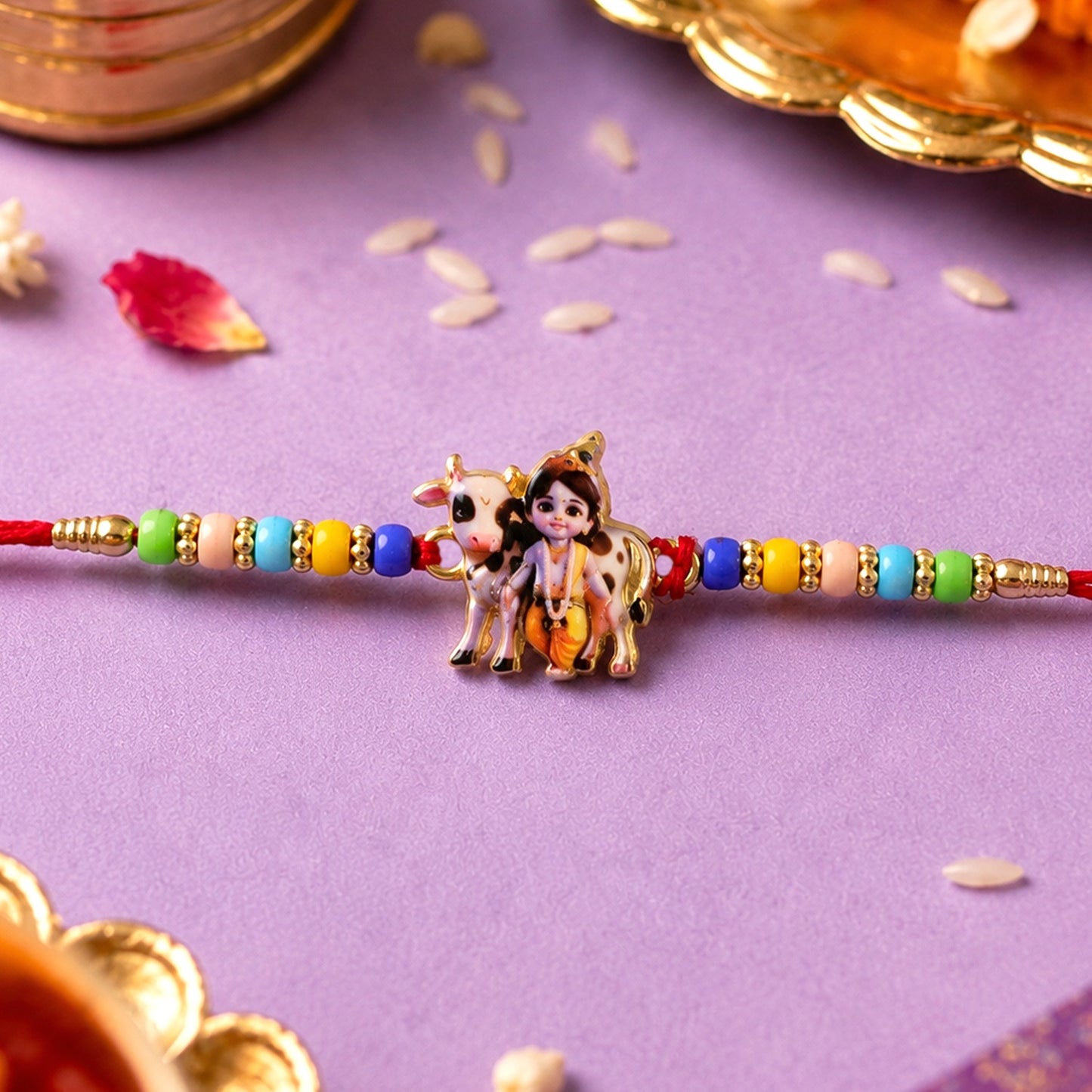 Lord Krishna Rakhi with cow motif on a red thread, perfect for Raksha Bandhan.