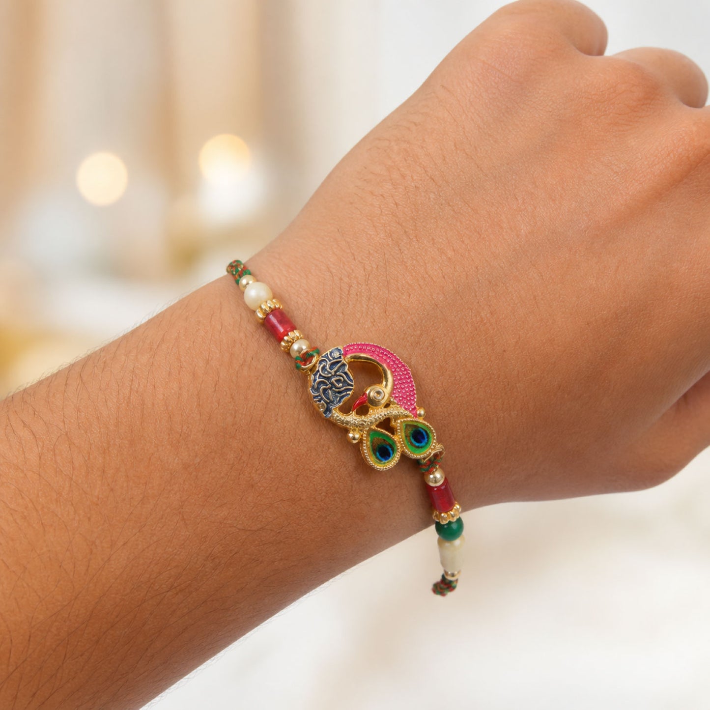 Peacock Rakhi Set with Red Thread, Gold Beads and Meenakari Accent Design