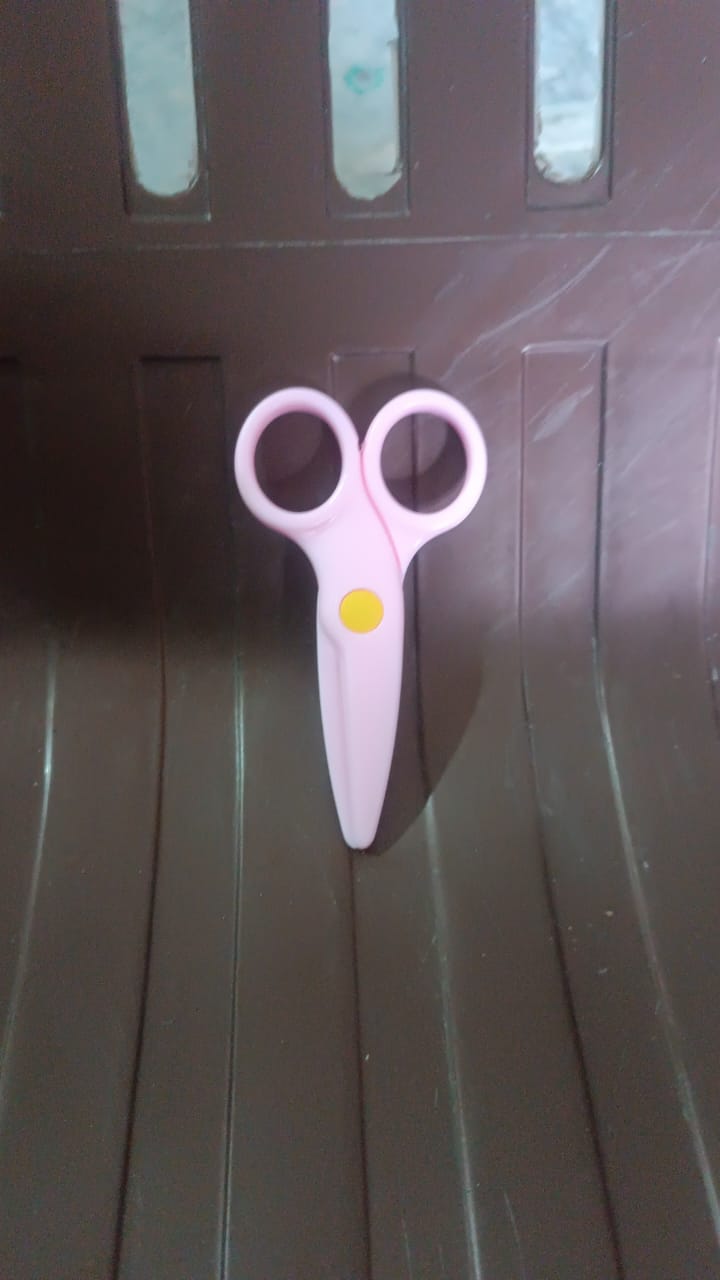 Child using the child-safe plastic scissors for arts and crafts