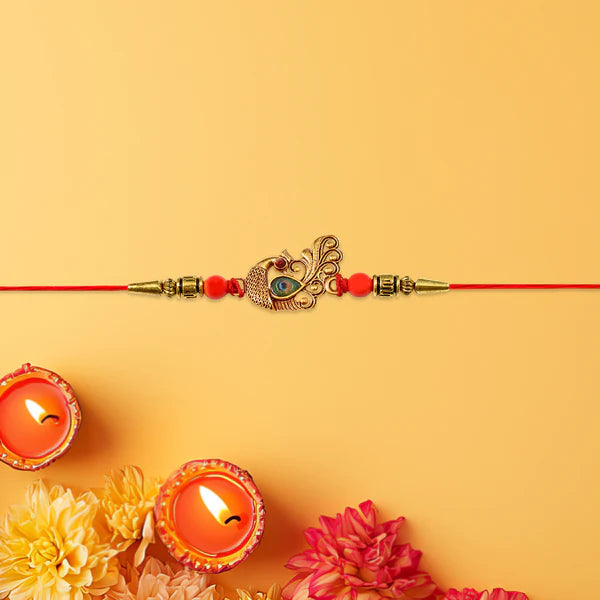 Elegant Peacock Rakhi for brother, designed with golden stones and decorative beads.