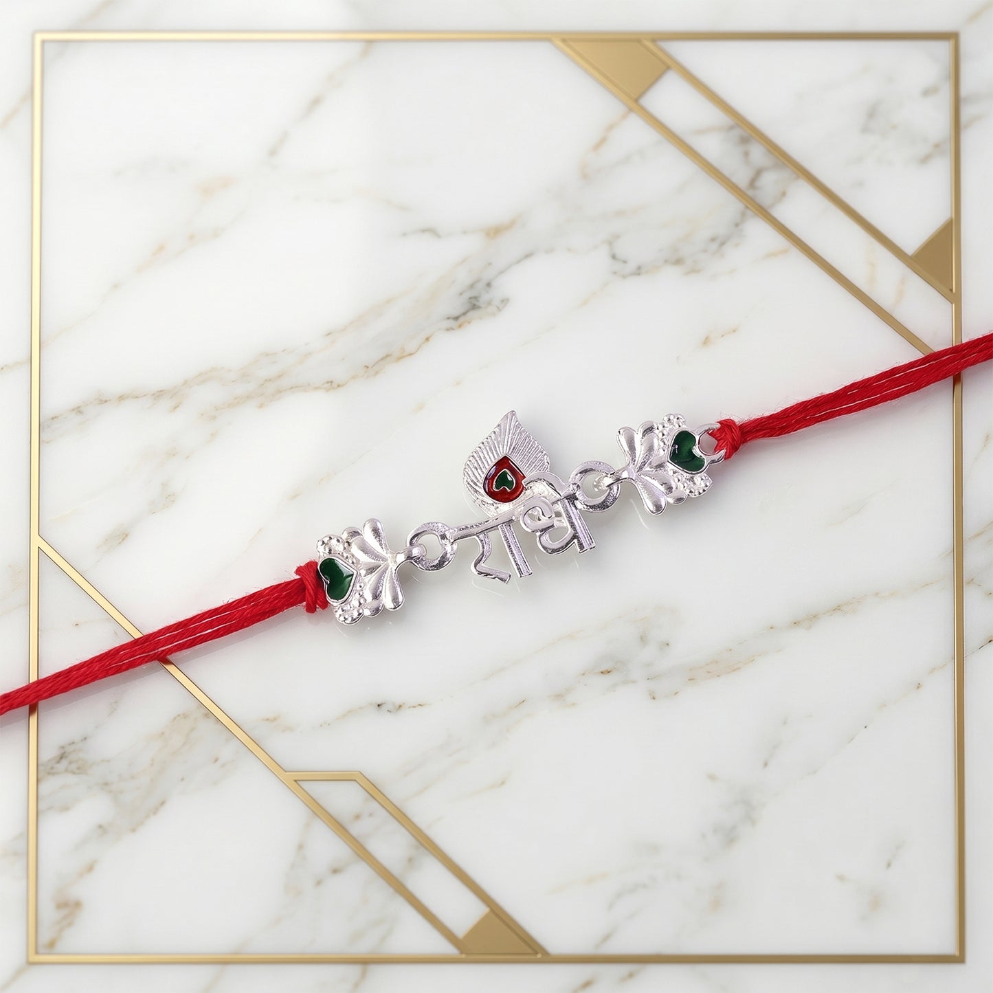 Silver Radhe Morpich Text Rakhi with Green Stones and Red Thread