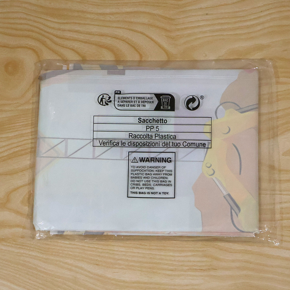 A folded construction-themed birthday banner sealed in a clear plastic bag with recycling information and a warning label.