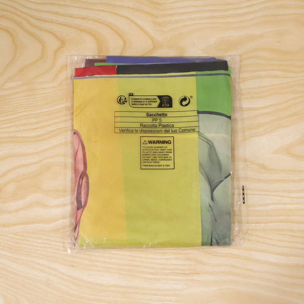 Actual photograph of folded birthday banner in plastic packaging
