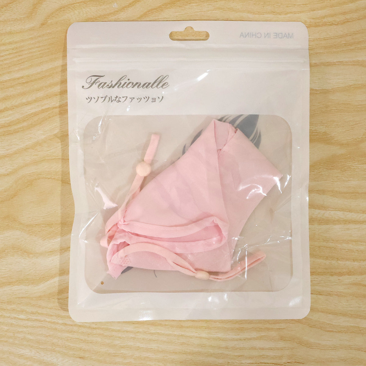 Actual photograph of face cover in plastic retail packaging