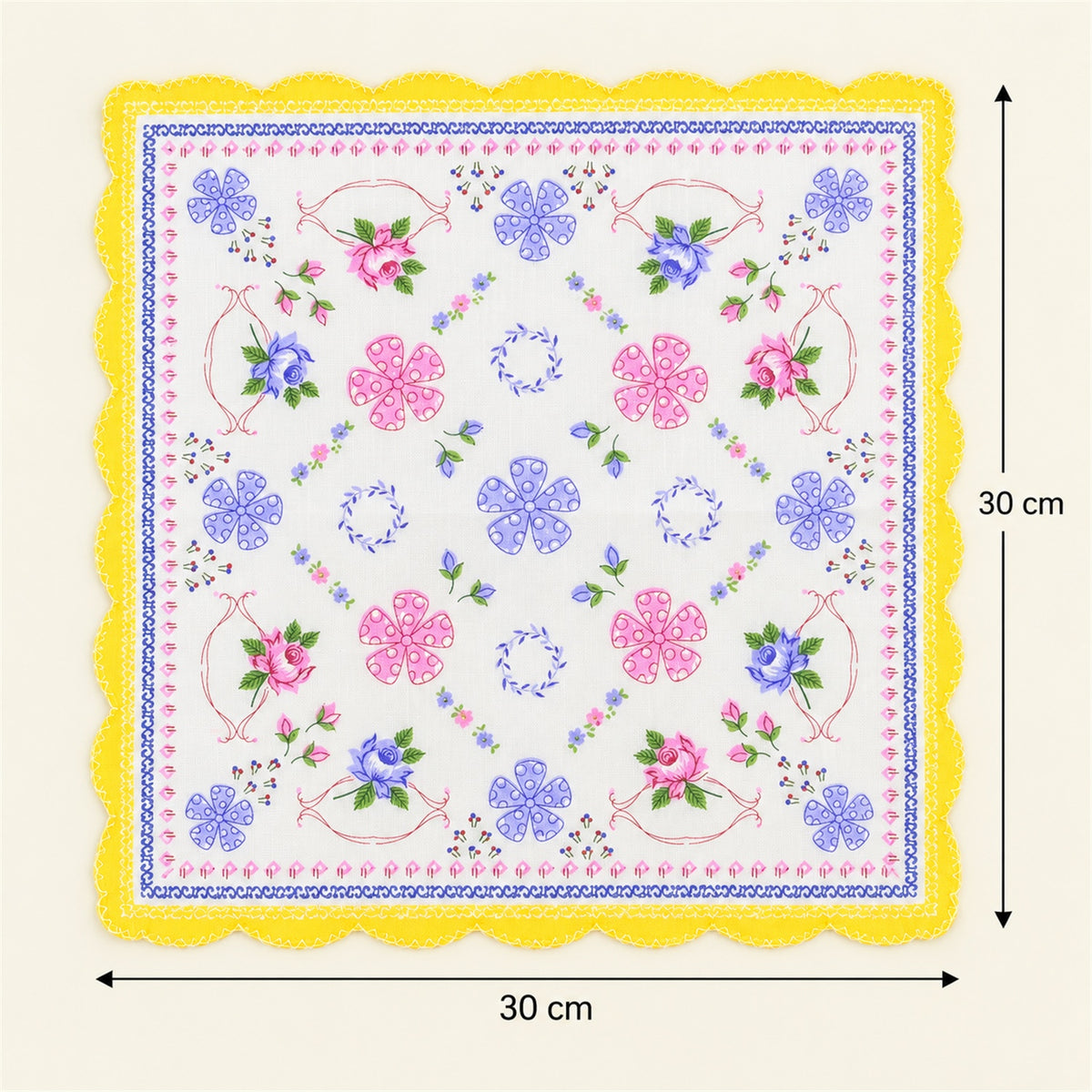 A white handkerchief with a yellow scalloped border and a detailed floral pattern is shown with measurements indicating