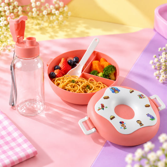 A pink donut-shaped lunch box, a clear water bottle, and a divided bowl filled with pasta, fruit, and vegetables on a