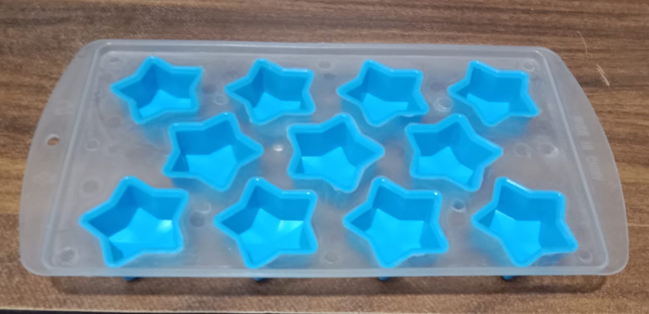 Overhead view of a silicone mold with various fruit and geometric ice cube shapes.
