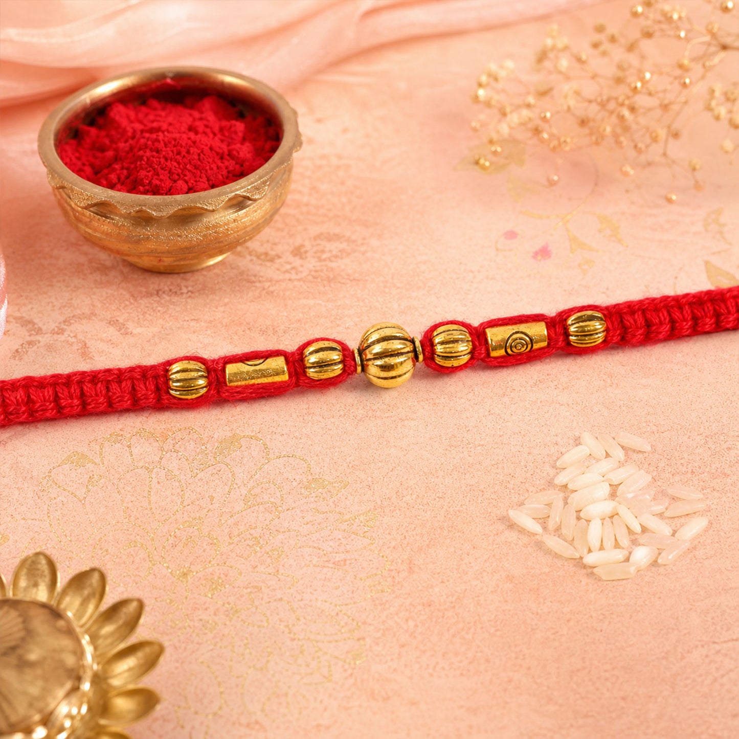 Red Braided Rakhi with a Row of Smooth Golden Bead Accents