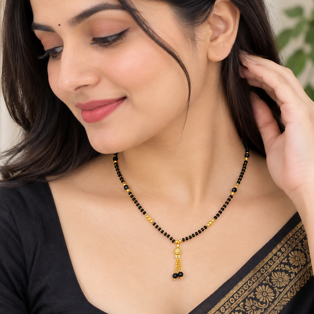 Close up of black beaded mangalsutra with hanging golden pendant