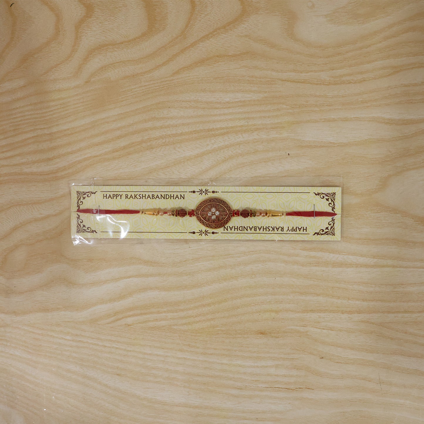 Round Red Chakra Rakhi with Golden Beads and Pearl Side Work