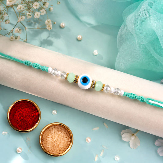 Front view of the Blue Evil Eye Nazar Charm Rakhi with its turquoise thread and beads.