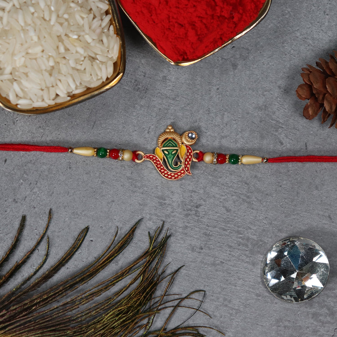Close-up view of the handcrafted Ganesha Rakhi showing detailed thread work.