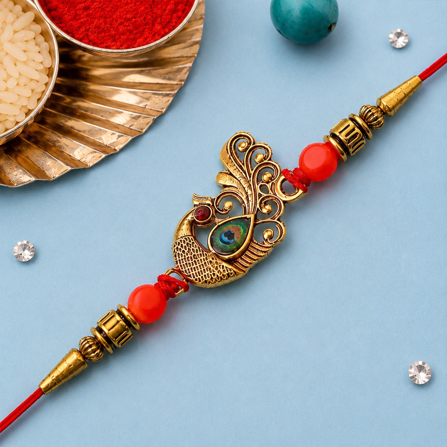 Close-up of a vibrant Peacock Rakhi with golden beads and colorful stones.