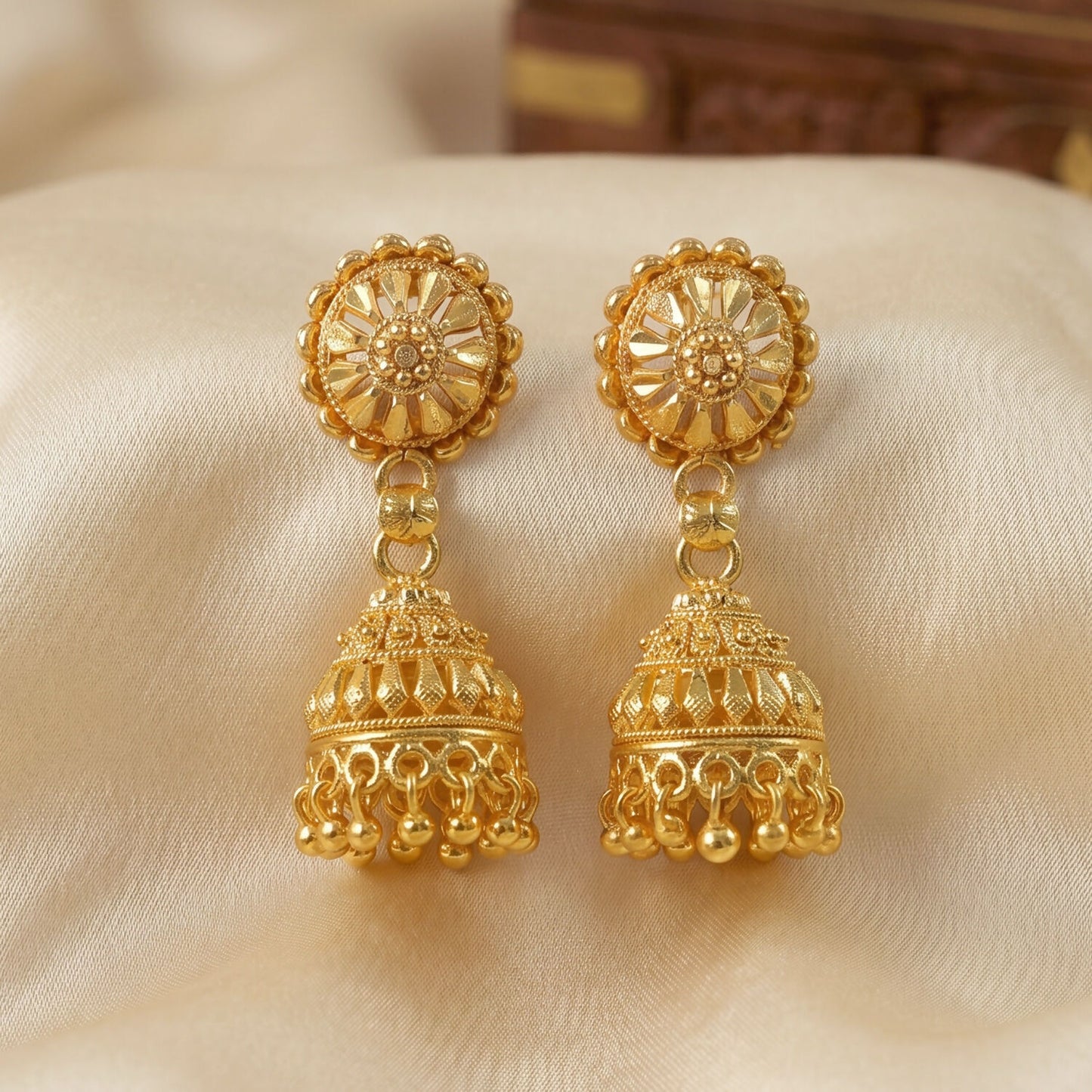 Gold jhumka earrings highlighting pearl accents
