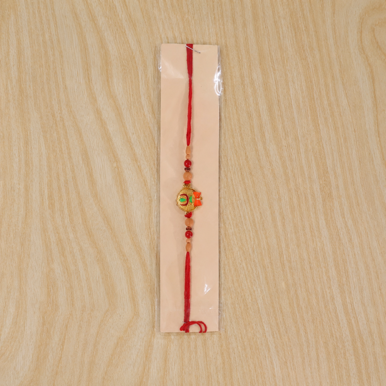 Tiny Trishul Damru Rakhi with Green Stone Center and Minimal Red Thread