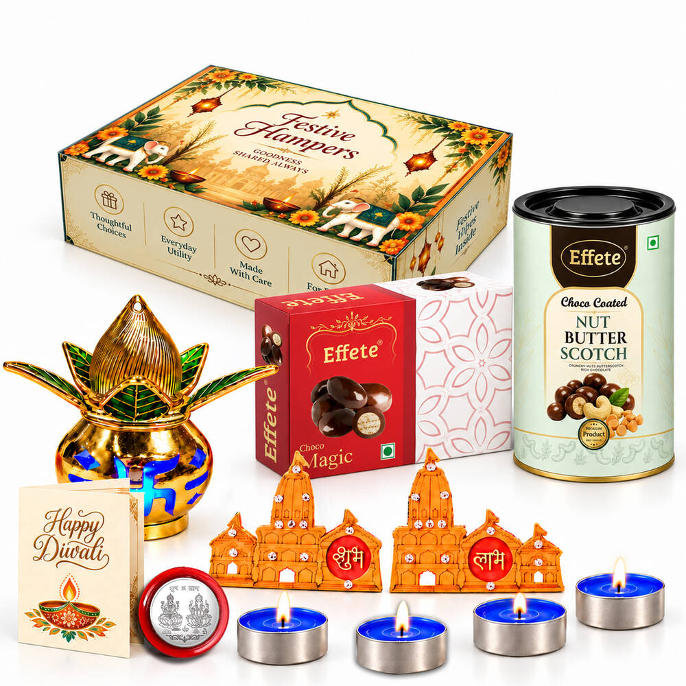 A festive gift box, a golden lotus diya, chocolates, nut butterscotch, tealights, and Shubh-Labh decor on a white surface.