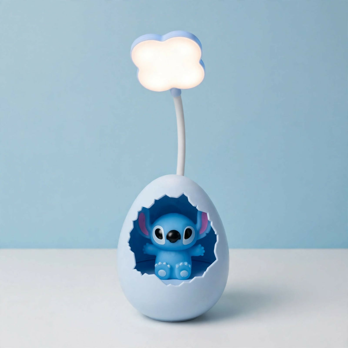 A light blue cracked egg lamp with a Stitch figure inside and a glowing cloud light on a flexible arm, against a plain blue
