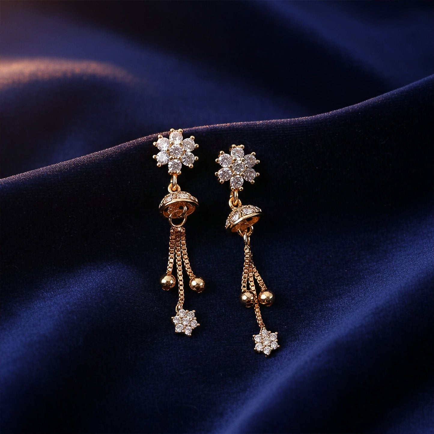 Close-up view of elegant floral crystal drop earrings with gold-tone dome and chain tassels