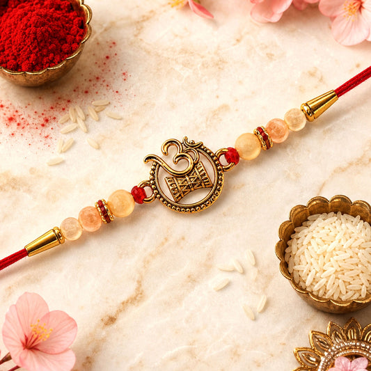 Beautiful Om Swastik Rakhi with golden motif and pearl beads on a red thread.