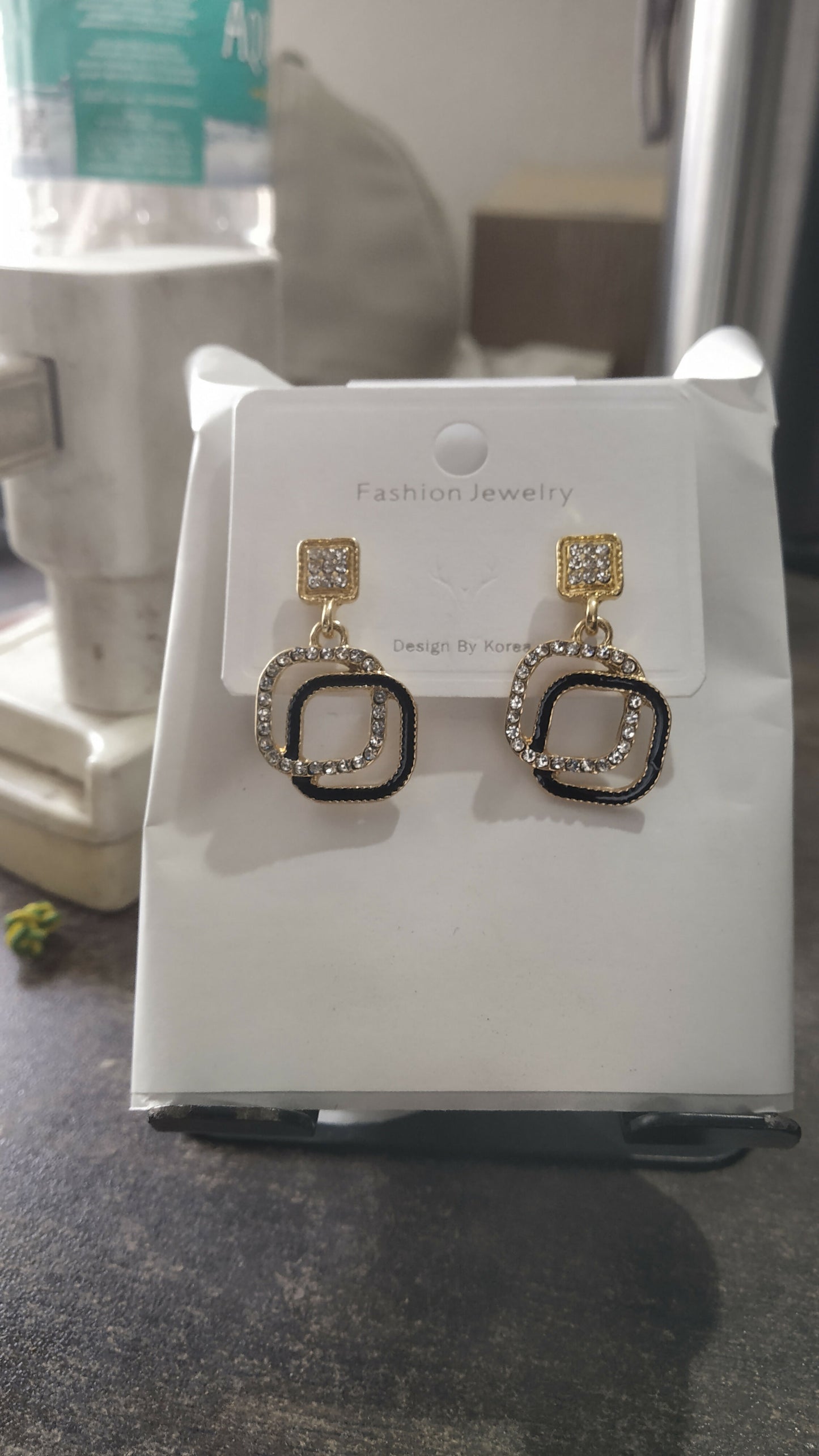 Black stone gold plated geometric earrings displayed on white background