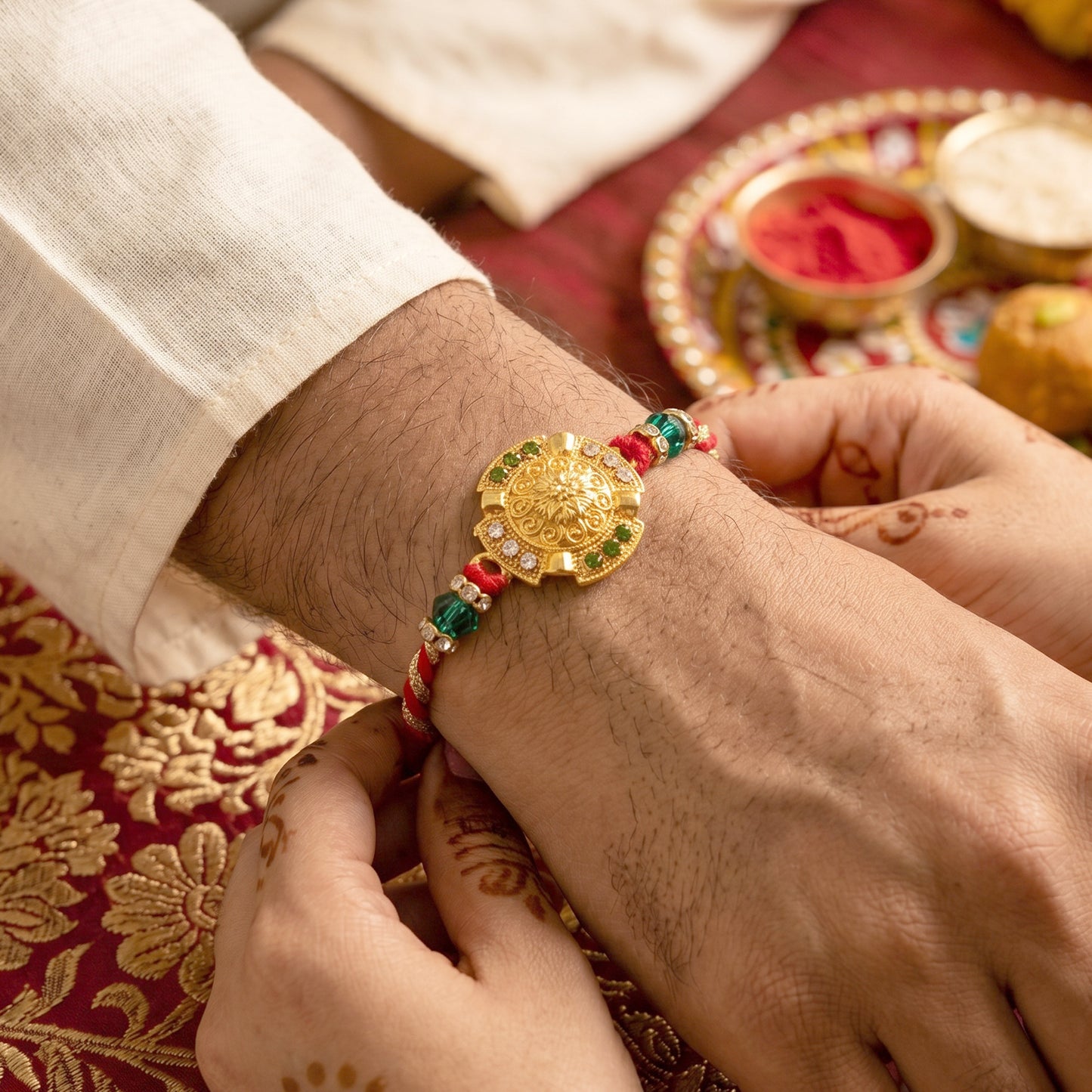 Traditional Gold Floral Coin Rakhi with Green Stone Beads