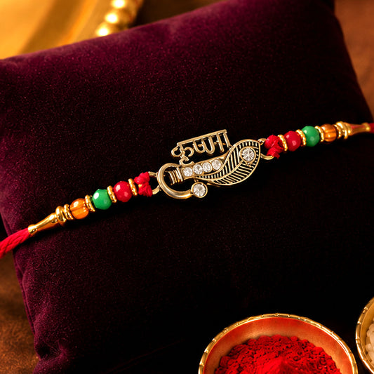 Close-up of Veera Name Rakhi with flute leaf design, stones, and red green beads.