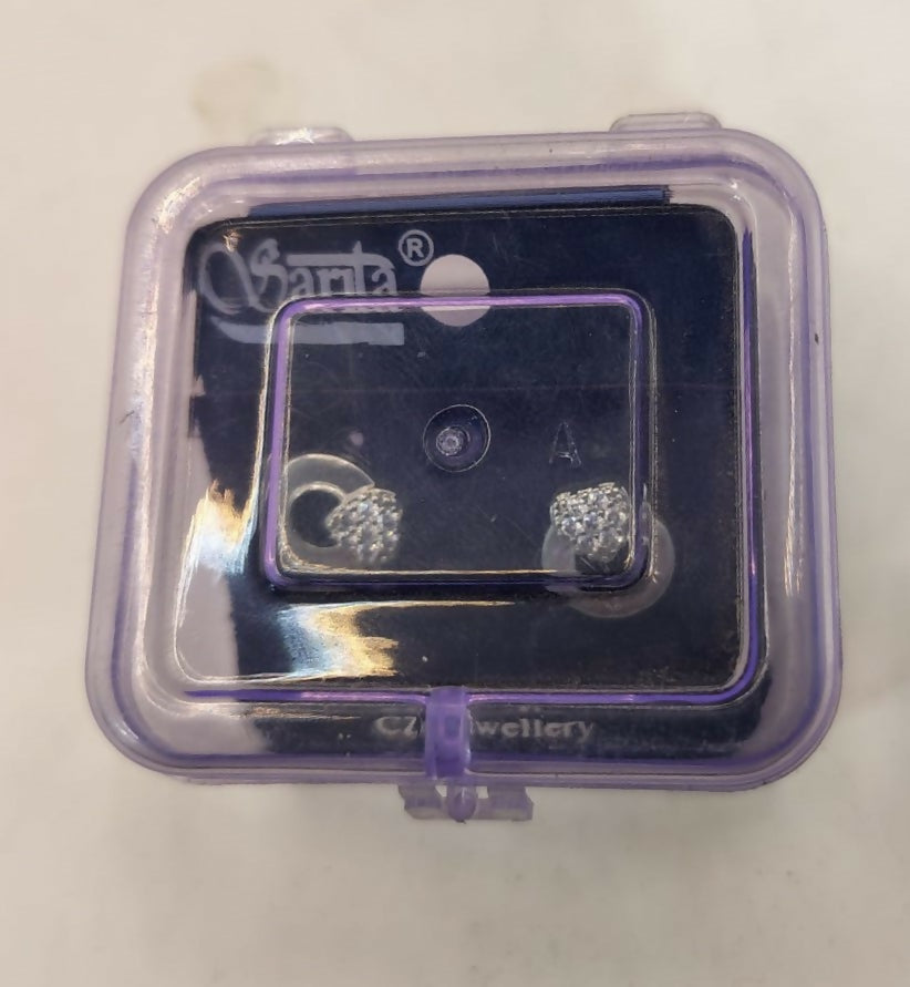 Lifestyle image of silver tone heart stud earrings worn on ear