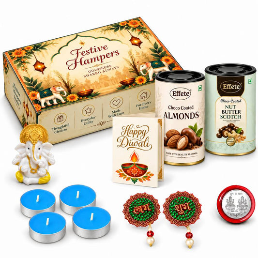 A festive gift box, two tins of nuts, a Ganesha idol, tealights, and decorative items are arranged on a white surface.
