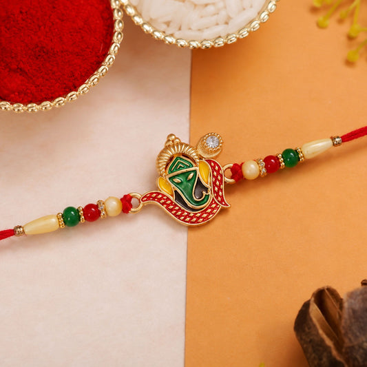 Elegant Ganpati Rakhi featuring red and green beads, perfect for Raksha Bandhan.