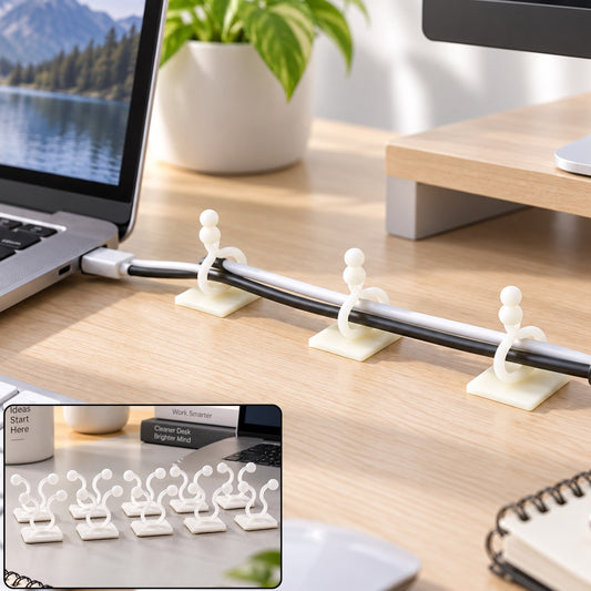 White self-adhesive clips securing black and white cables to a light wooden desk next to a laptop.