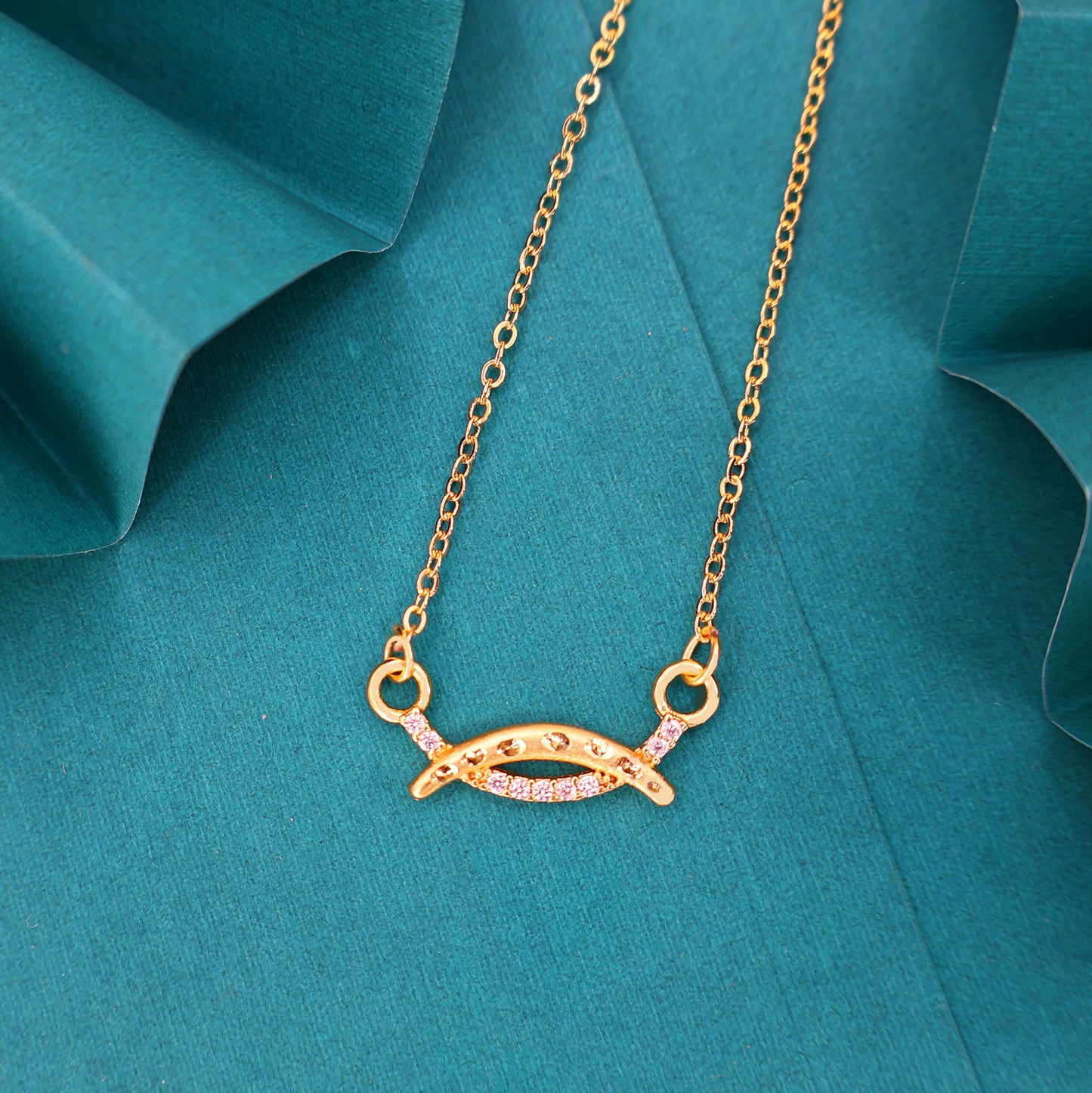 Close-up of gold plated necklace's marquise-shaped charm with pavé cubic zirconia detailing