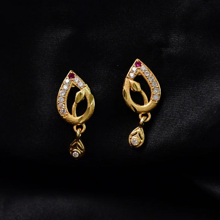 Side view of gold teardrop earrings with rubies and crystals