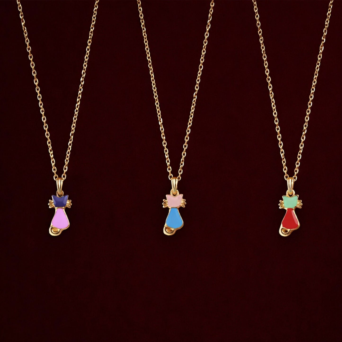 Close-up of gold cat pendant necklace showing vibrant enamel details