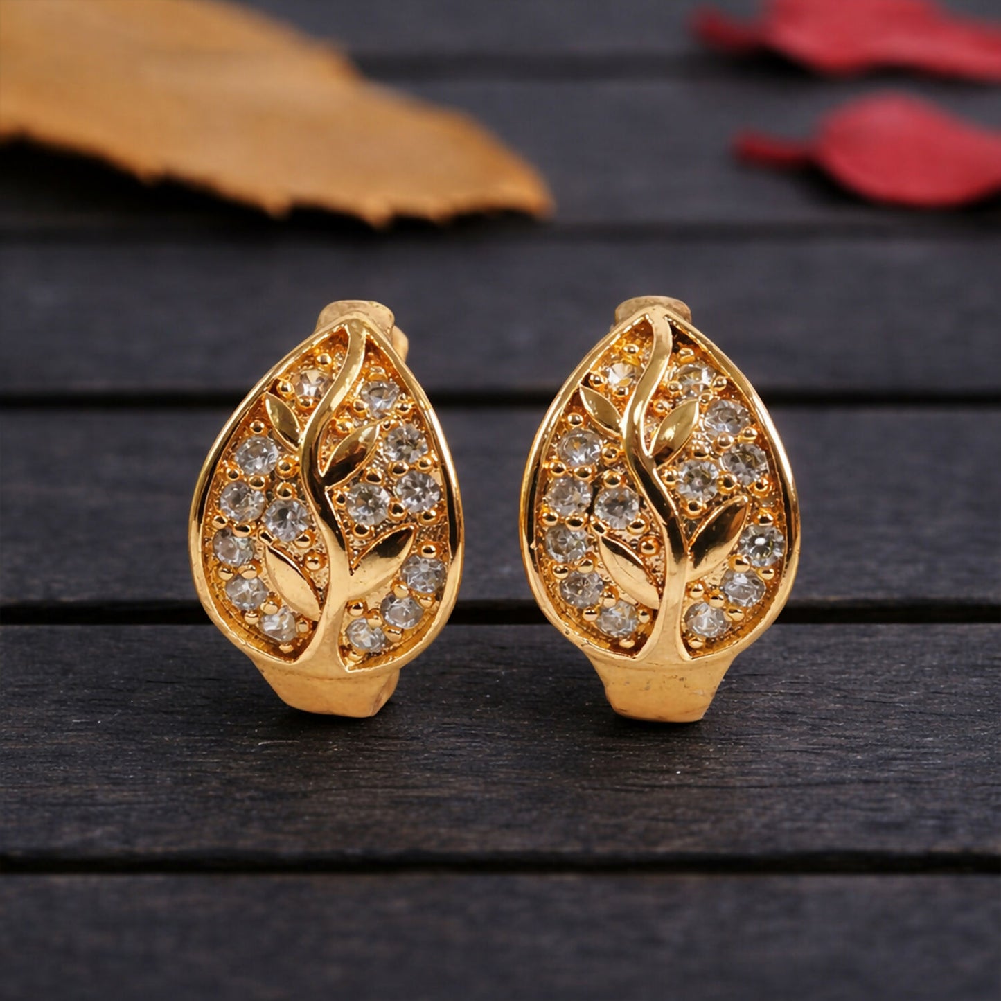 Gold-tone leaf design stone stud earrings showcasing elegant sparkle